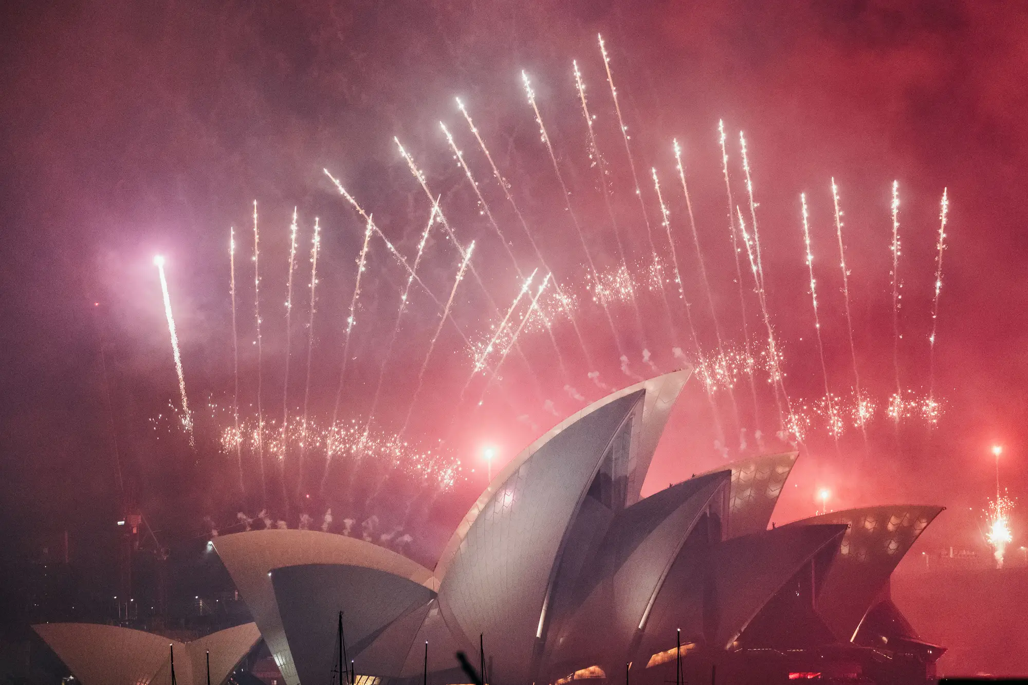 Fireworks rising over the sails of the Sydney Opera House on New Year's Eve