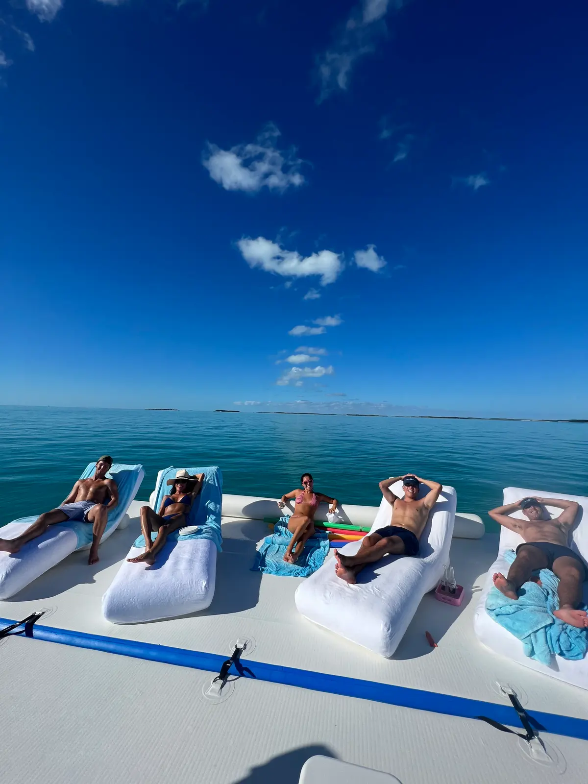 Five loungers on the floating platform, noodles and towels, nothing but banks behind